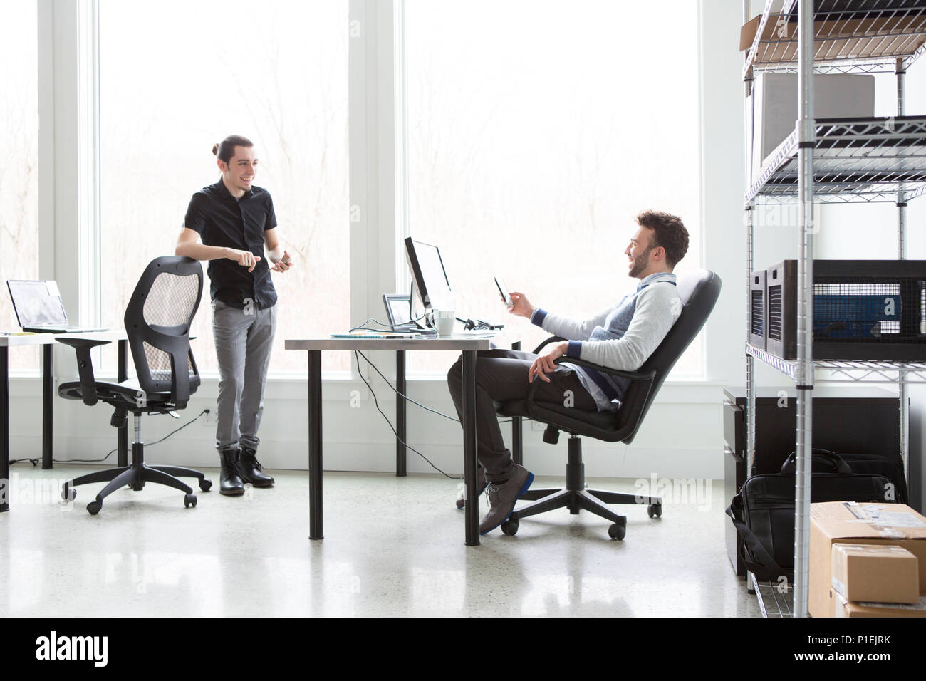 Junge Geschäftsleute mit einem unbeschwerten Moment beim Brainstorming in einem hellen, modernen Office.Business-Konzept. Stockfoto
