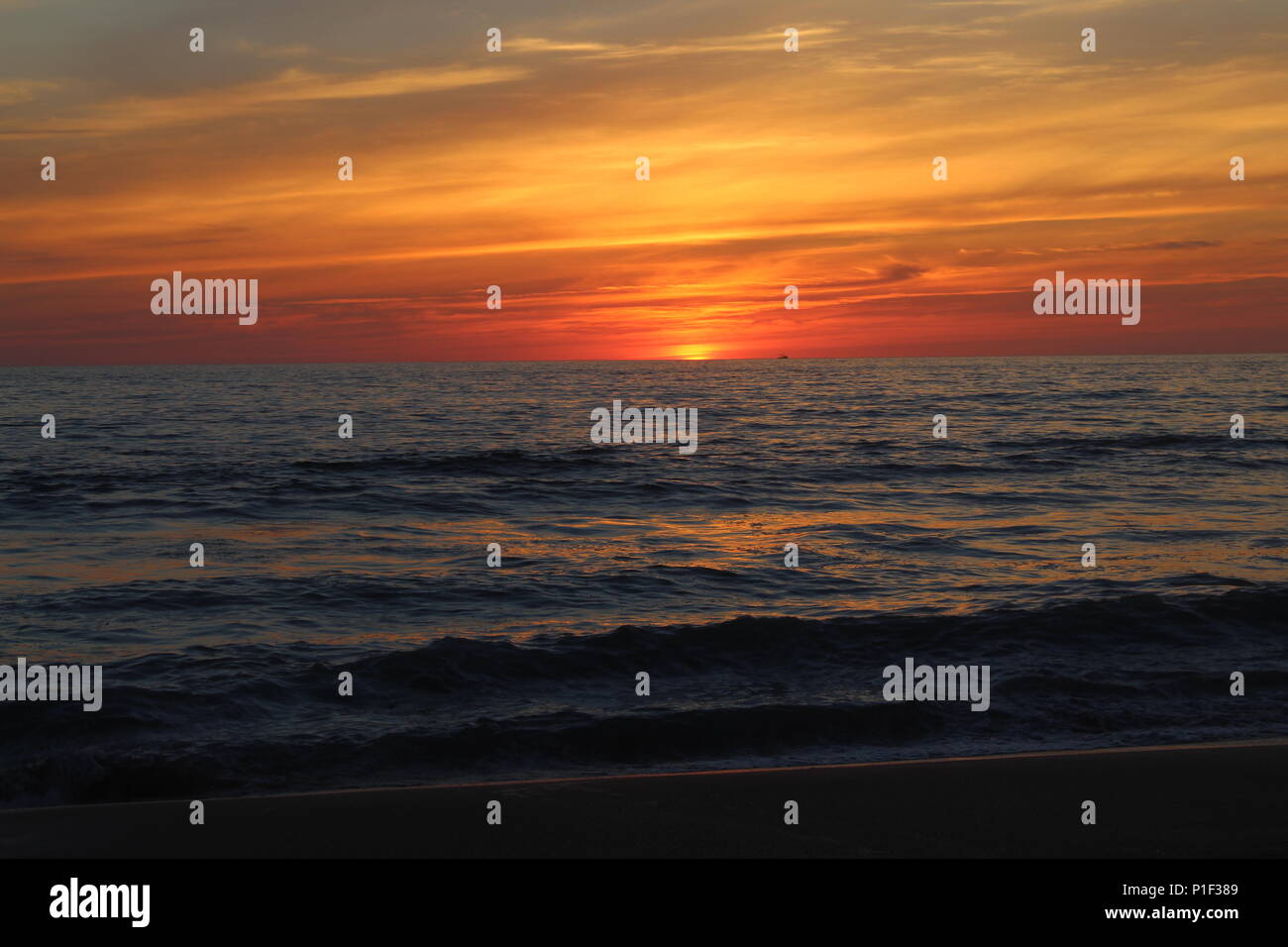 Dieses Bild zeigt einen wunderschönen Sonnenuntergang an der Westküste von Mexiko, Mit einer schönen Anzeige von warmen Farben über eine harmonische Meer. Stockfoto