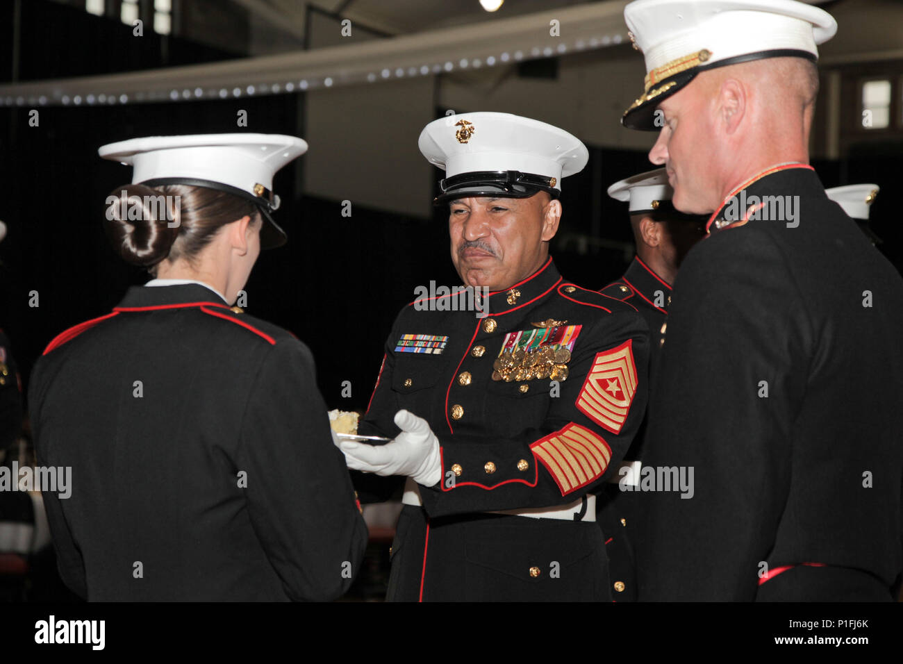 Us Marine Corps Sgt. Maj. Miguel A. Rodriguez, Mitte, Sergeant Major des Marine Corps Combat Service Support Schulen (MCCSSS), übergibt das Stück Kuchen für die jüngsten Marine während der Student Marine Corps Geburtstag ball Zeremonie in Camp Lejeune, N.C., Okt. 29, 2016 statt. Studenten aus finanziellen Management School, Masse der Schule, Personalverwaltung Schule, und die Logistik eine Schule besucht haben, Ihre erste Marine Corps Ball der 241 Marine Corps Geburtstag zu feiern. (U.S. Marine Corps Foto von Lance Cpl. Jose D. Villalobosrocha) Stockfoto