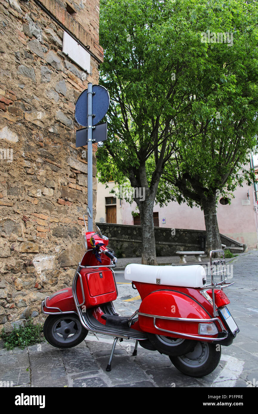 Rot Roller auf der Straße von Montalcino Stadt geparkt, Val d'Orcia, Toskana, Italien. Scooter ist eine sehr beliebte lokale Transportmittel. Stockfoto