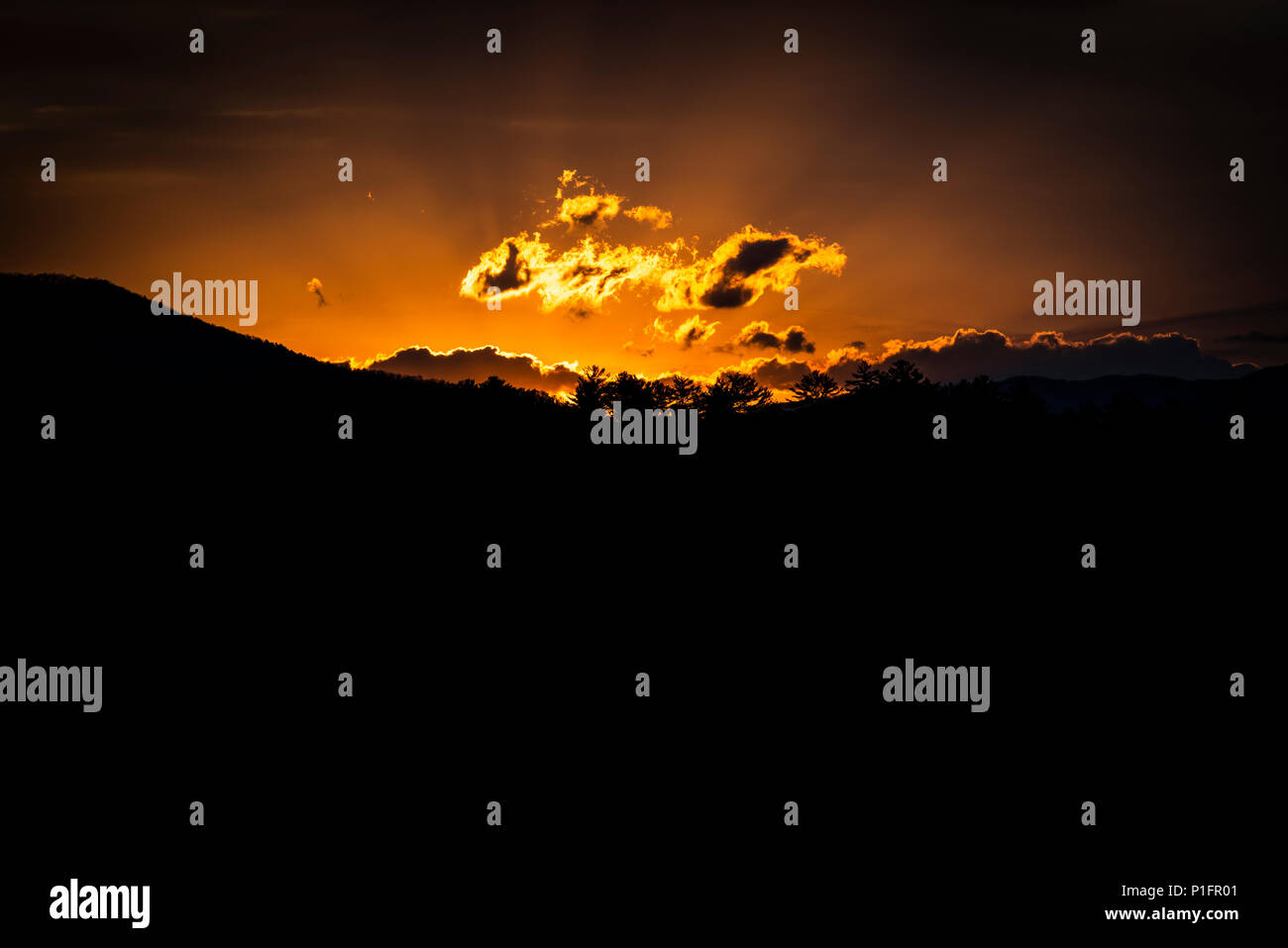 Horizontale Schuß eines leuchtenden Berge Sonnenaufgang mit einem schwarzen Vordergrund und Kopieren. Stockfoto