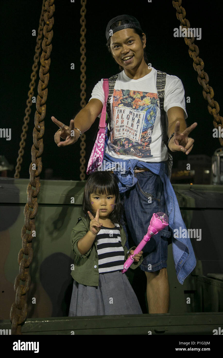 Okinawa Bewohner Pose auf einem Humvee während Kinser Festival 2016 am Okt. 30 an Bord Camp Kinser, Okinawa, Japan. Kinser Festival begrüßte alle Status der Einsatzkräfte Vereinbarung Personal und Okinawa Bewohner ein Wochenende des Festivals Spaß mit Attraktionen für alle Altersgruppen zu genießen. Während des Festivals, die Teilnehmer hatten die Gelegenheit, eine statische Darstellung von Fahrzeugen und Geräten durch die 3. Marine Logistics Group, III Marine Expeditionary Force in Camp Kinser verwendet. (U.S. Marine Corps Foto von Cpl. Douglas D. Simons/Freigegeben) Stockfoto