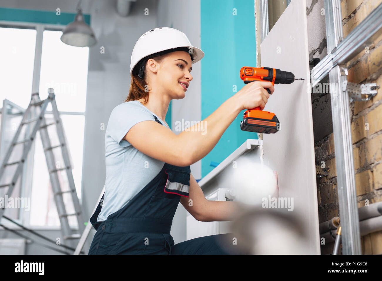 Inhalt weiblichen Builder arbeiten mit einem Bohrer Stockfoto