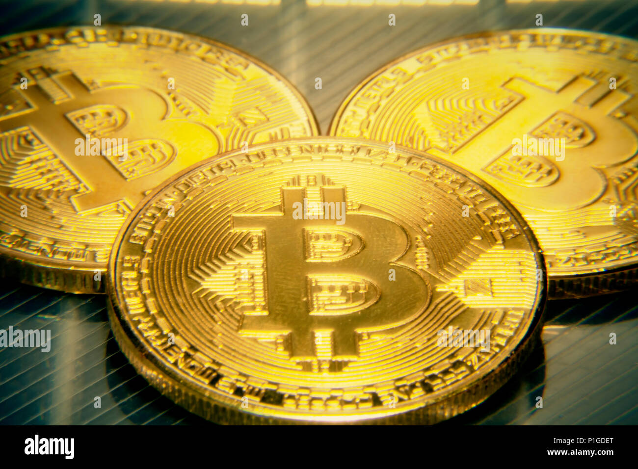 Makro mojo Nahaufnahme: drei physischen golden Bitcoins (digitale virtuelle crypto-Währung) auf einer semi-transparente Oberfläche. Stockfoto