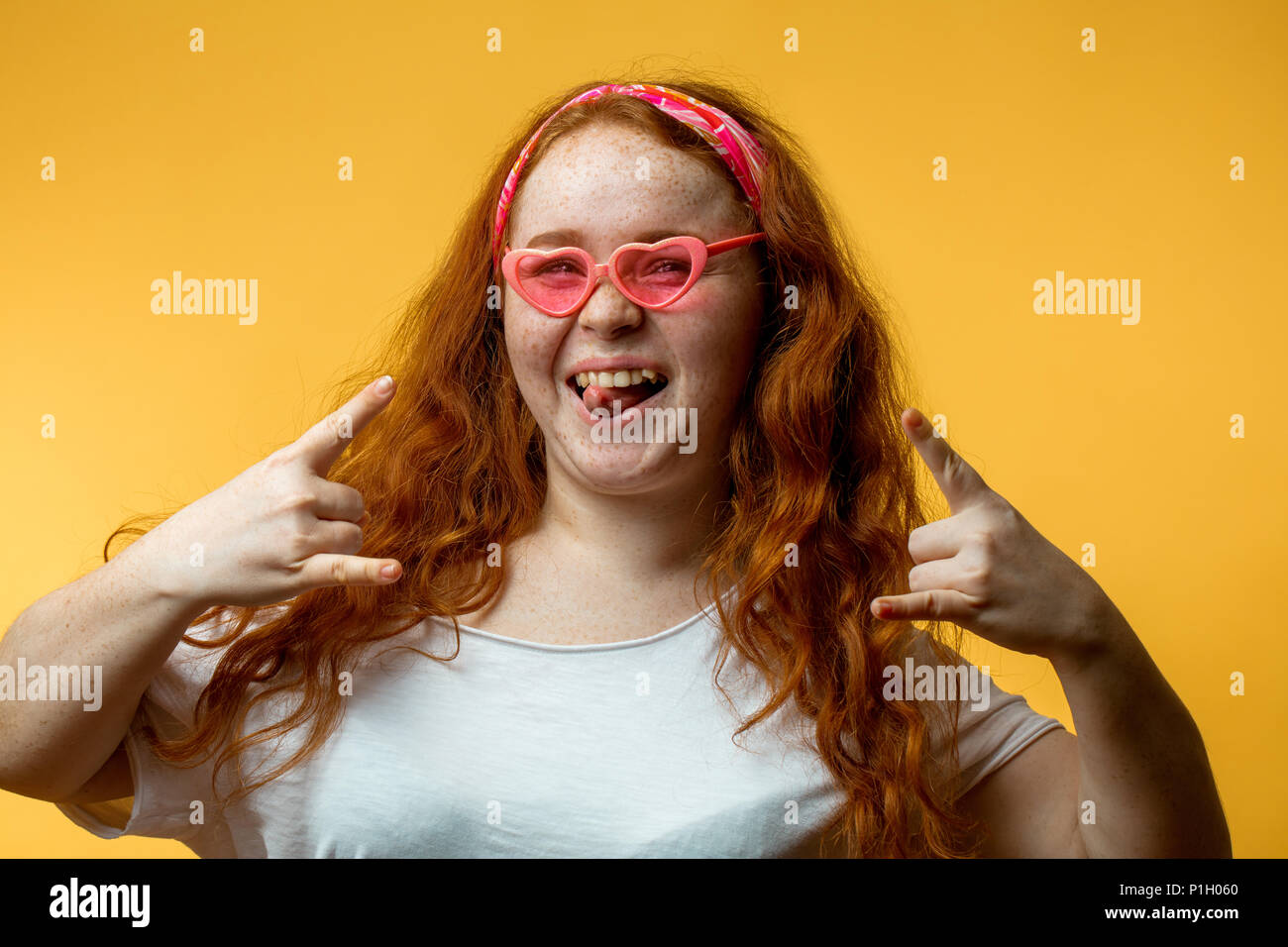 Porträt der schönen Lächeln rothaarige Mädchen mit grossen Fashion Pink Gläser Stockfoto