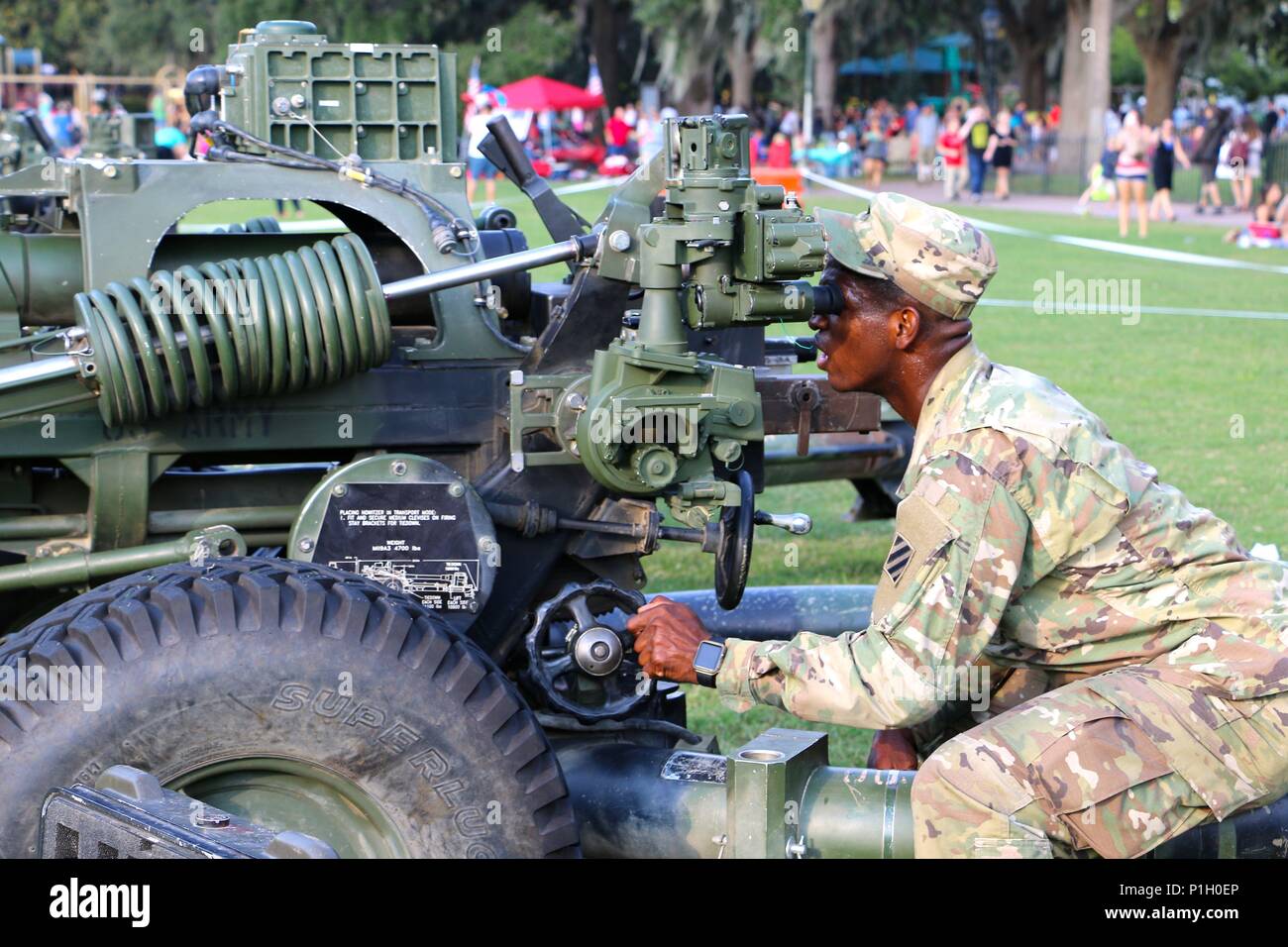 Soldat des 1. Bataillons, 9. Feldartillerieregiment, 3. Infanteriedivision Artillerie stellt eine 105-mm-leichte Haubitze M119A3 im Forsyth Park, Savannah, Georgia während des „Picknick in the Park“ Community Relations-Events ein. Die Demonstration umfasst Artillerieeinsätze, Zieleinstellungen und betriebliche Sicherheitsverfahren. Die Haubitze M119A3, ausgestattet mit digitaler Feuerkontrolle und hoher Mobilität, wird verwendet, um Feldartillerie-Ausbildung und Öffentlichkeitsarbeit zu unterstützen und der Gemeinde die Fähigkeiten der Artillerie zu zeigen. Stockfoto