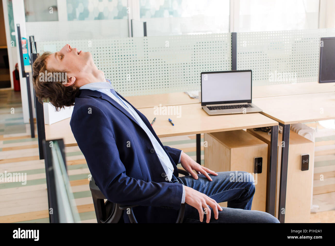 Junge müde Geschäftsmann am Arbeitsplatz Ruhe Stockfoto