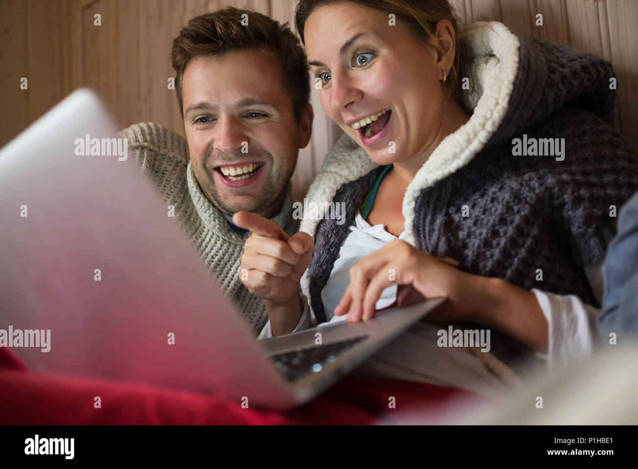 Gerne europäische Familie beim Einkaufen mit Laptop im Internet. Mann und Frau sind glücklich und lächelte sie an, Nachrichten form Freunde sprechen mit App. Conce Stockfoto