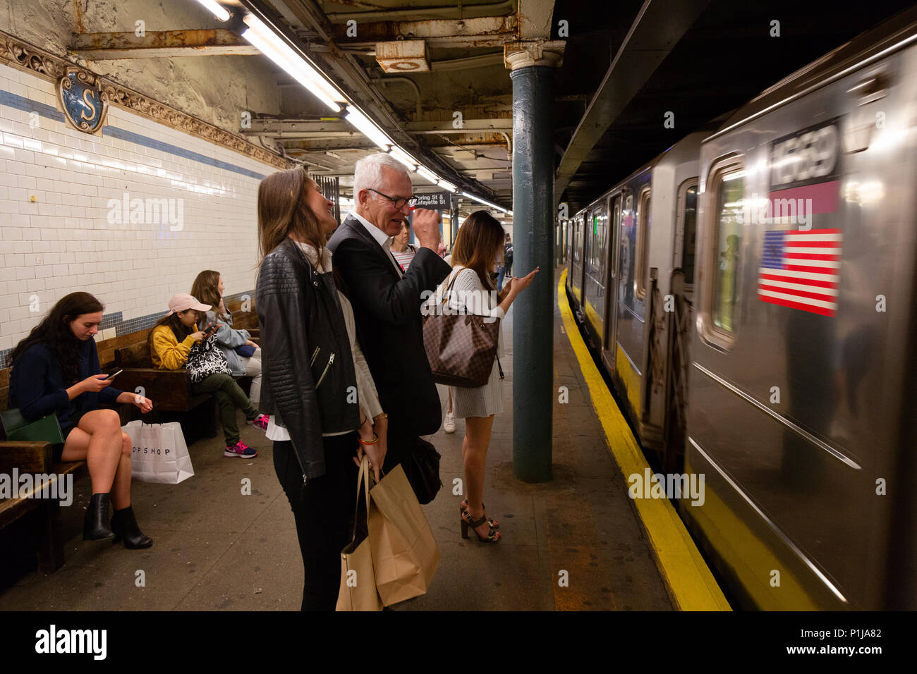 Passagiere auf einem Bahnsteig warten, da die U-Bahn Zug kommt, die New Yorker U-Bahn, New York City, USA Stockfoto
