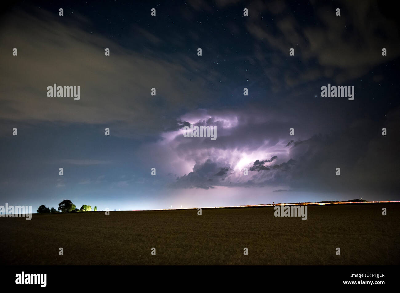 Gewitter mit wetterleuchten unter dem Sternenhimmel in der Nähe von Butzbach, Hessen, Deutschland Stockfoto