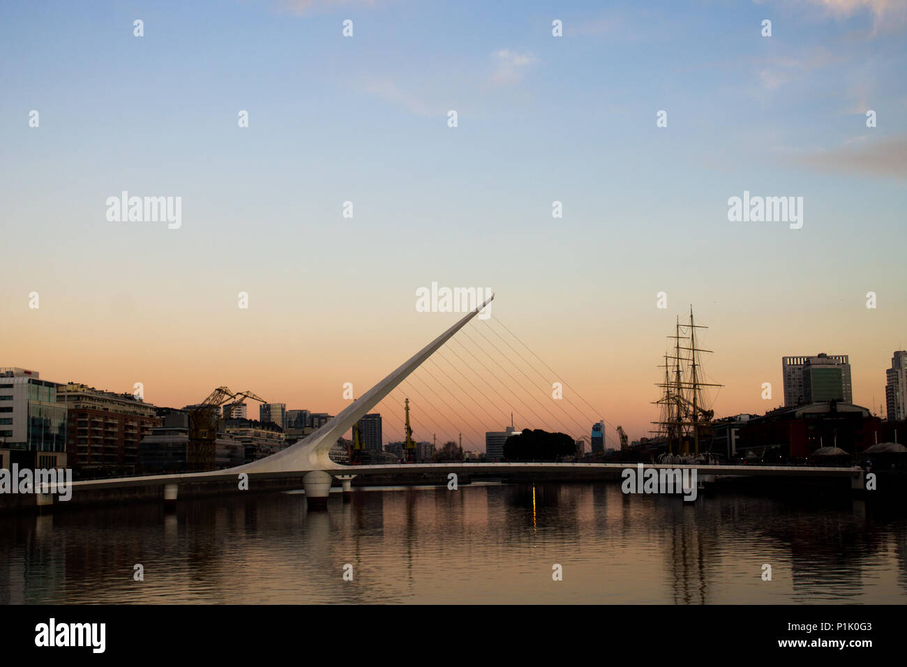 Die Puente de La Mujer Fußgängerbrücke in Puerto Madero in Buenos Aires, Argentinien in der Abenddämmerung. Stockfoto
