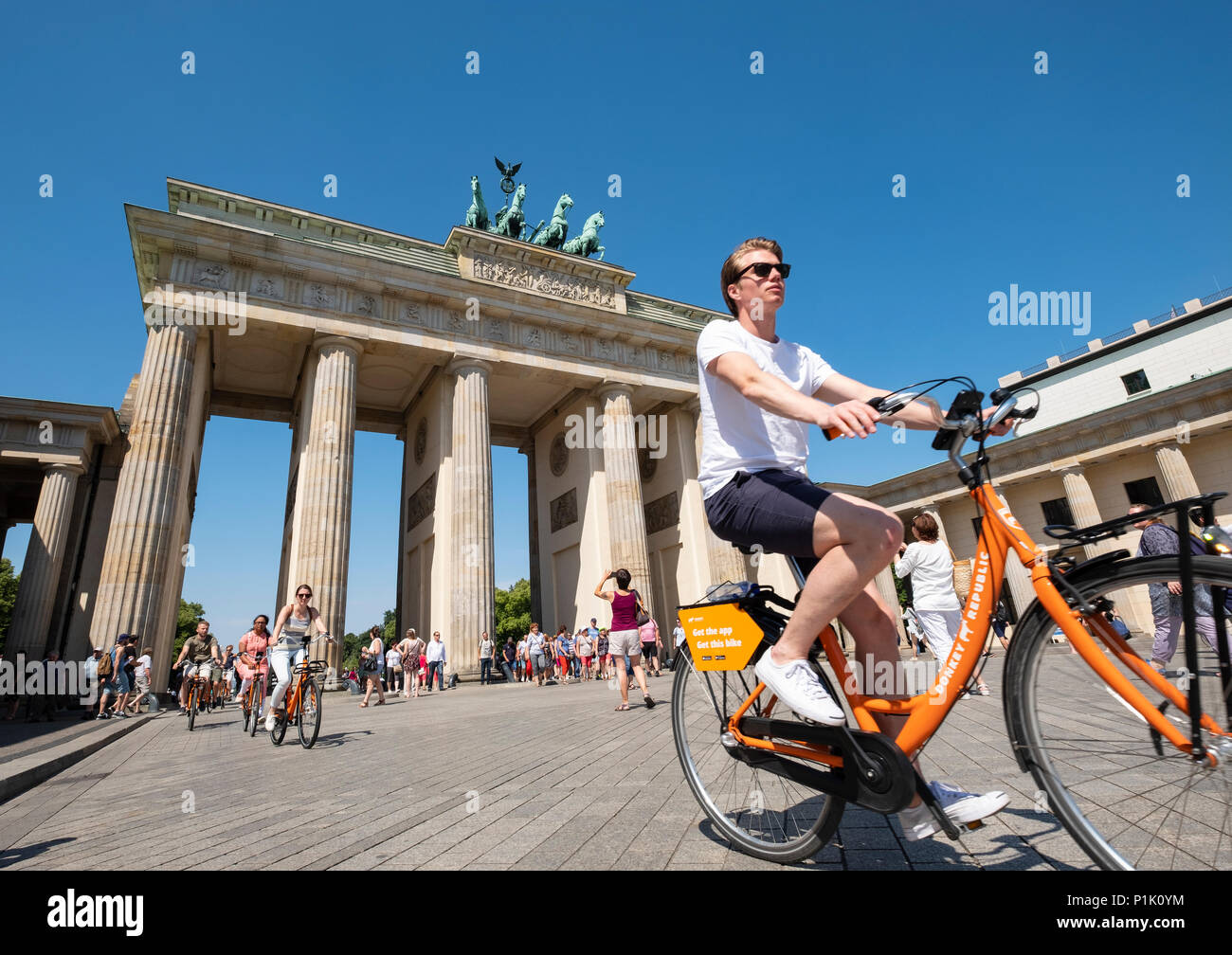 Touristen auf Fahrrädern vor dem Brandenburger Tor in Berlin, Deutschland Stockfoto