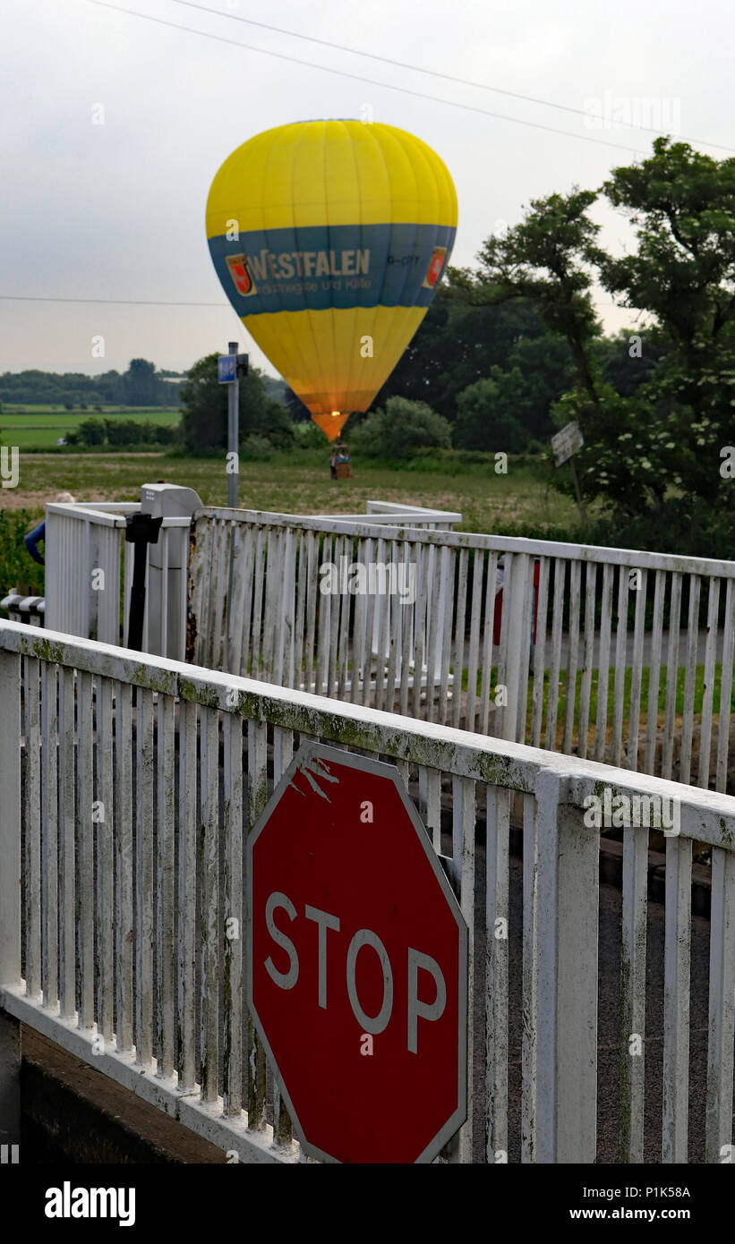 Ein grosser gelber Ballon landet im Feld eines Bauern, der auf der gegenüberliegenden Seite des Leeds und Liverpool canal jenseits der Crabtree Lane Swing Bridge. Stockfoto