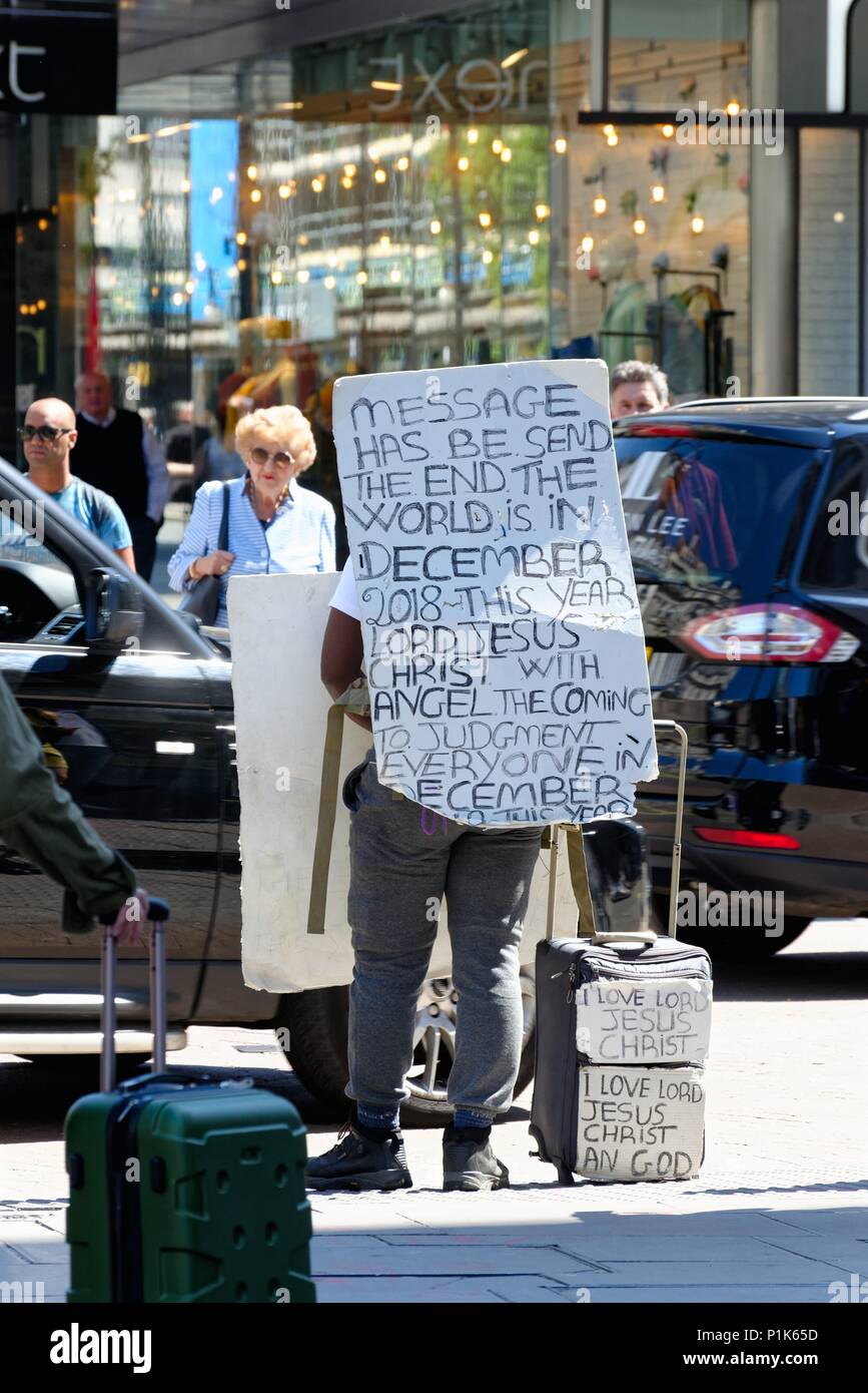 Ein Mann geht auf der Oxford Street, Londons mit einem selbstgemachten Zeichen auf dem Rücken der Bekanntgabe, dass das Ende der Welt, England, Großbritannien Stockfoto