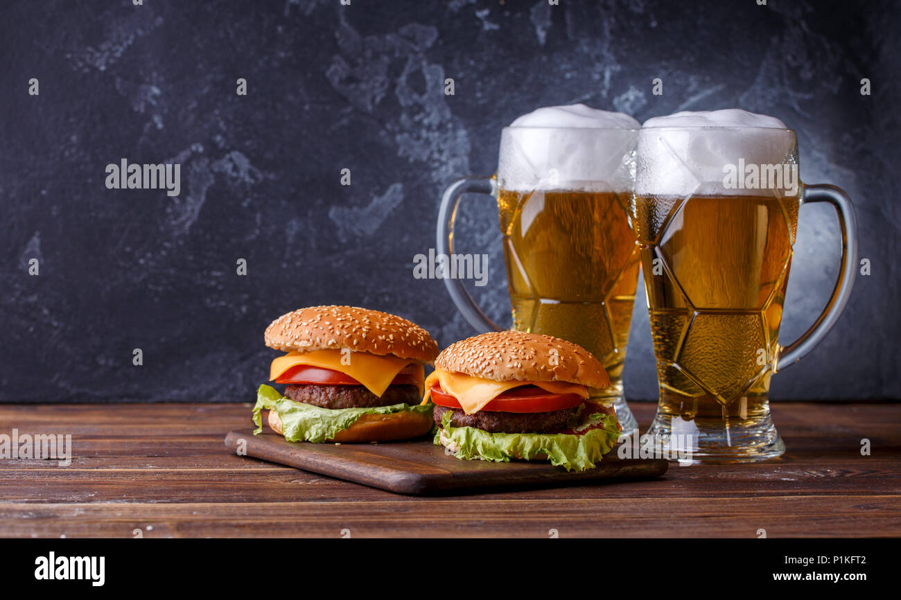 Foto von zwei Hamburger, Gläser mit Bier Stockfoto