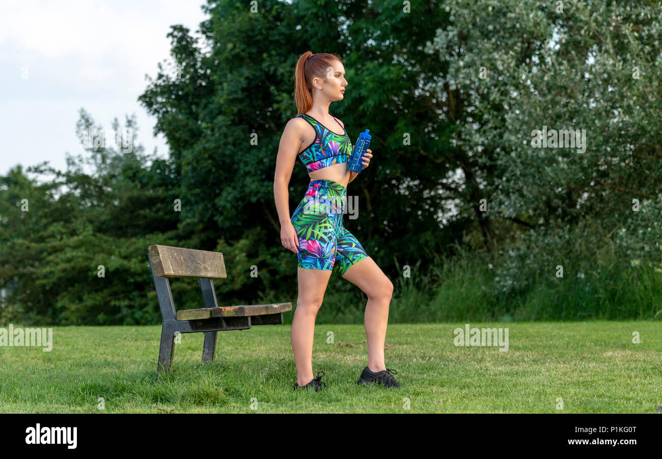 Frau sportswear Holding eine Flasche Wasser zur Erfrischung während der Übung Stockfoto