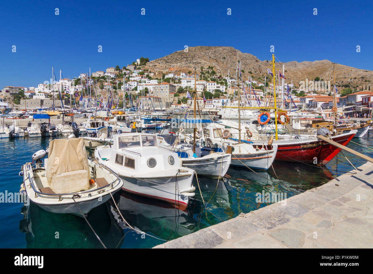 Die Stadt Hydra Hafen mit kleinen Fischerbooten durch das Cafe gesäumten Uferpromenade, Hydra übersehen gefüllt, Griechenland Stockfoto