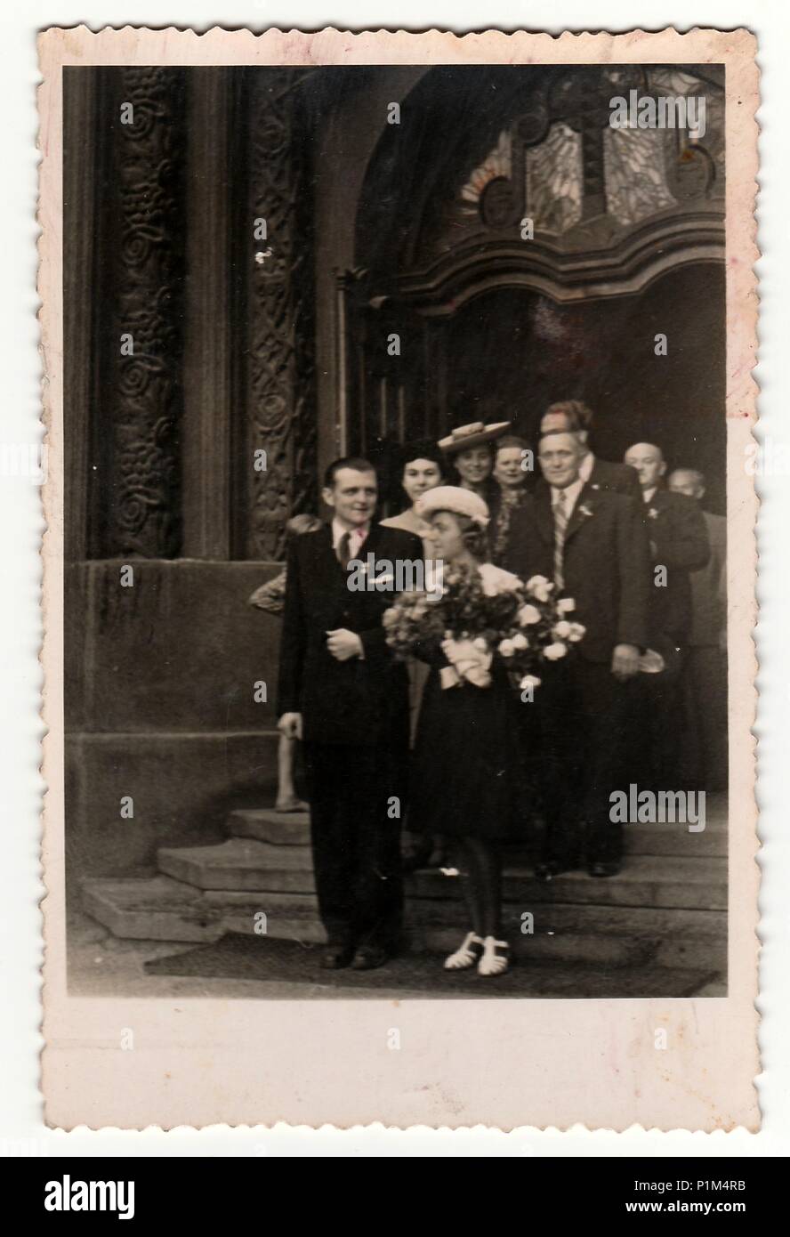 PRAHA (Prag), der TSCHECHOSLOWAKISCHEN SOZIALISTISCHEN REPUBLIK - ca. 1950er Jahre: Retro Foto zeigt das Brautpaar und Hochzeitsgäste auf Treppen von Dom (Kirche). Schwarz/Weiß-Fotografie. Stockfoto