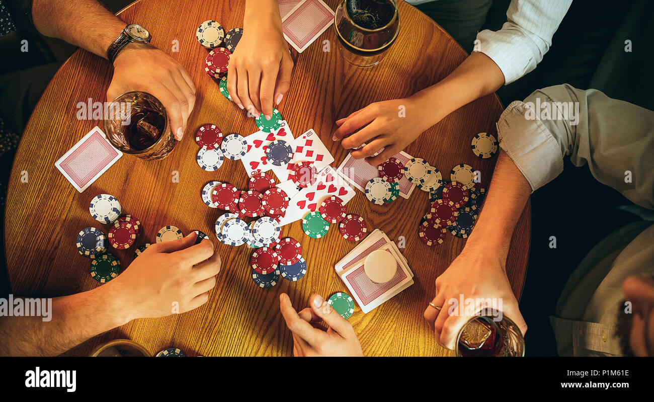 Ansicht von oben Foto von Freunden an den hölzernen Tisch sitzen. Freunde Spaß beim Spielen Brettspiel. Stockfoto