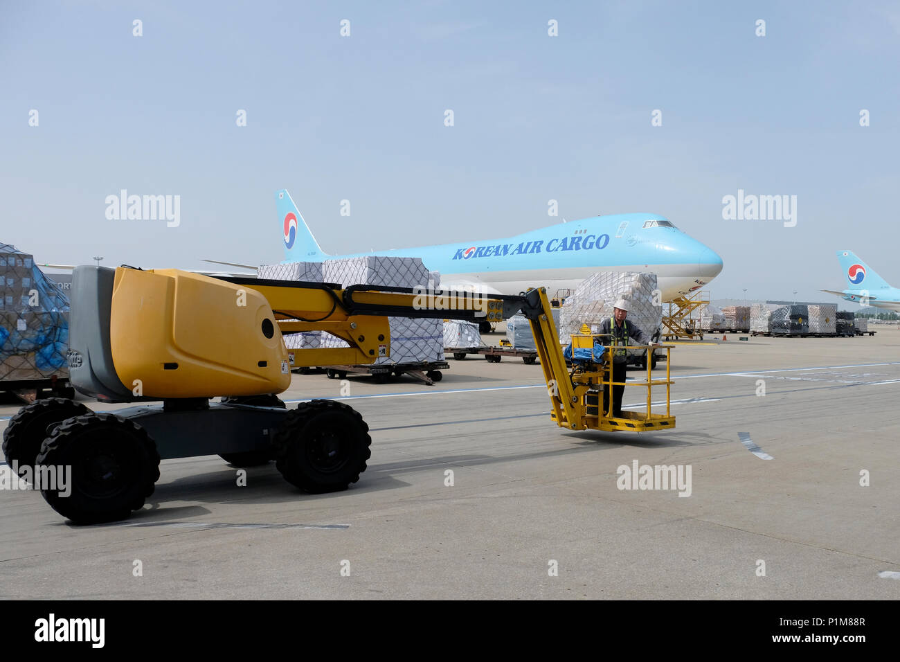 Ein Arbeitnehmer, der an einem Gabelstapler Vergangenheit Korean Air Lines Co. Fracht Flugzeuge auf der Rollbahn am Cargo Terminal des Unternehmens geparkt in Incheon International Airport manchmal als Seoul - Incheon International Airport der größte Flughafen in Südkorea liegt westlich der Stadt Incheon Stockfoto