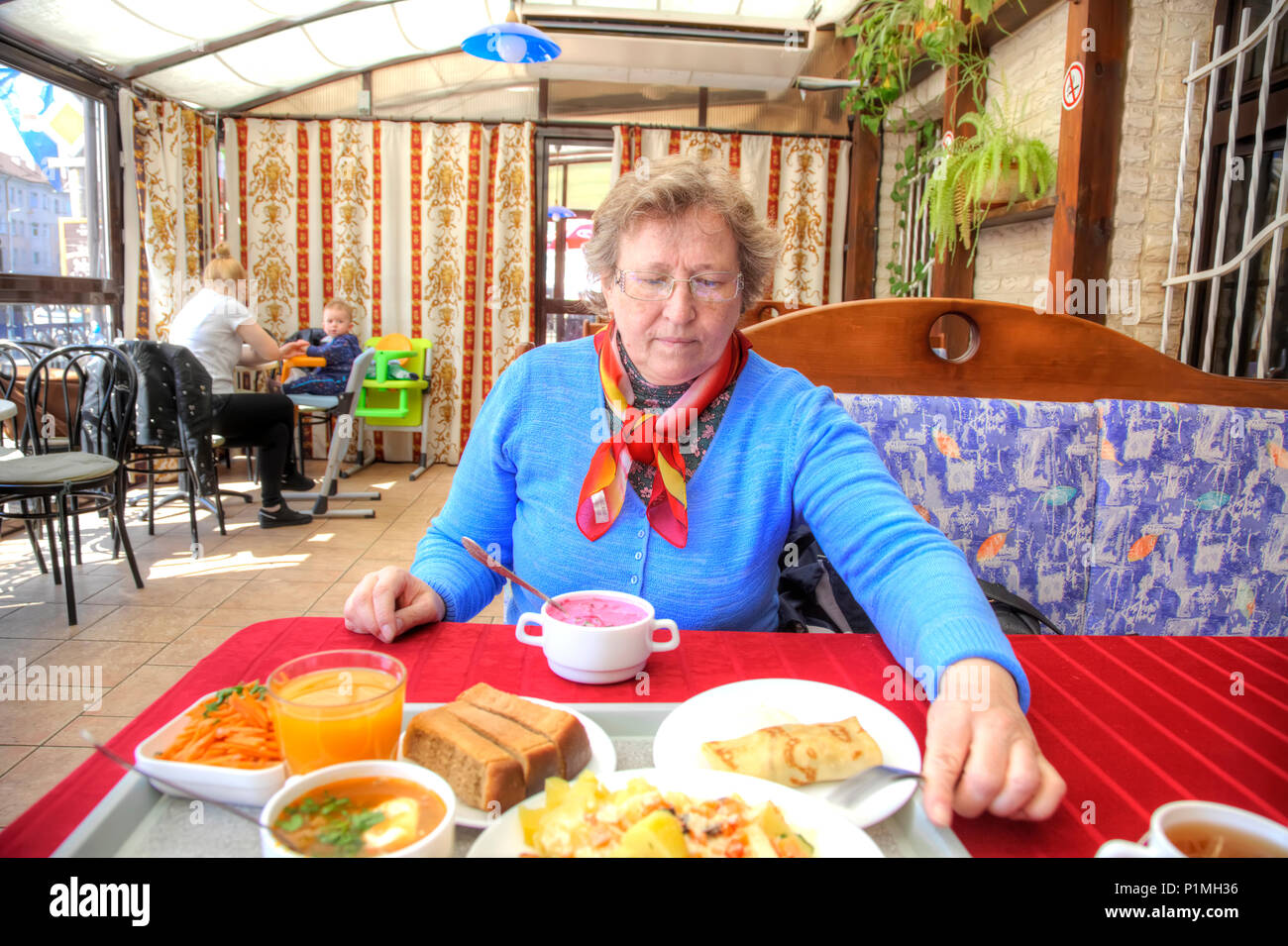 KALININGRAD, Russland - Mai 04.2018: Komplexe Mittagessen in der City Cafe. Eine Frau sitzt an einem Tisch in einem Cafe Stockfoto