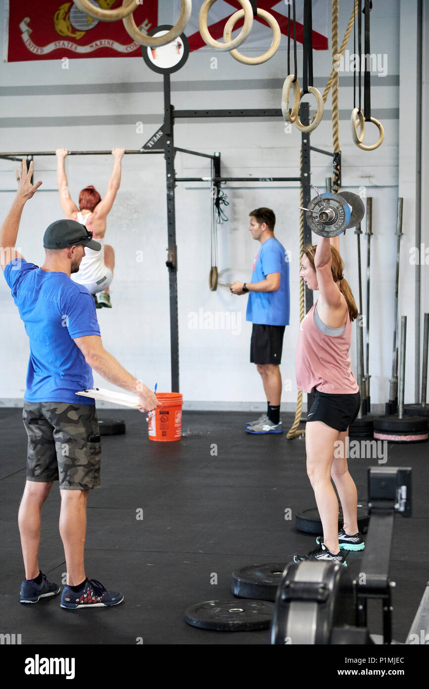 Weibliche oder Frau in einer CrossFit Fitness Challenge Wettbewerb durch tote Gewichte in einer Turnhalle in Montgomery Alabama, USA konkurrieren. Stockfoto