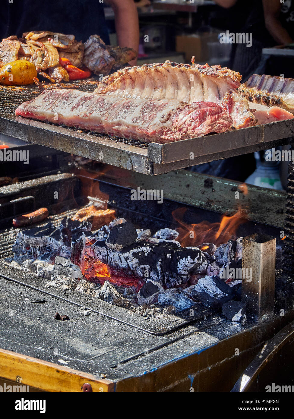 Schweinerippchen auf Holzkohle Grill in einem Stall eines Street Food Fair. Stockfoto