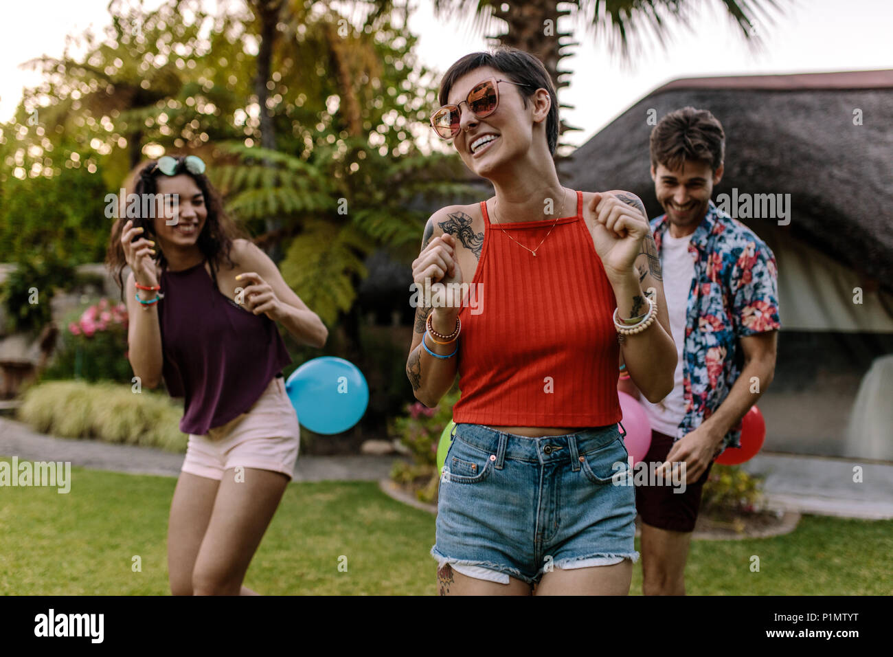 Menschen spielen Balloon popping Spiel auf einer Party. Männer und Frauen versuchen, Burst, jede andere Ballons. Stockfoto