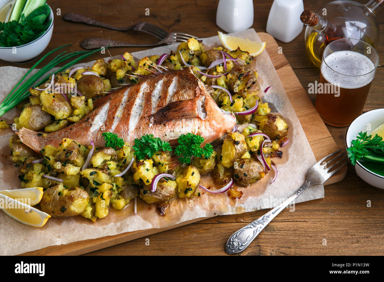 Gebackene Zackenbarsch oder roter Zackenbarsch mit Kartoffeln, Ansicht von oben. Stockfoto