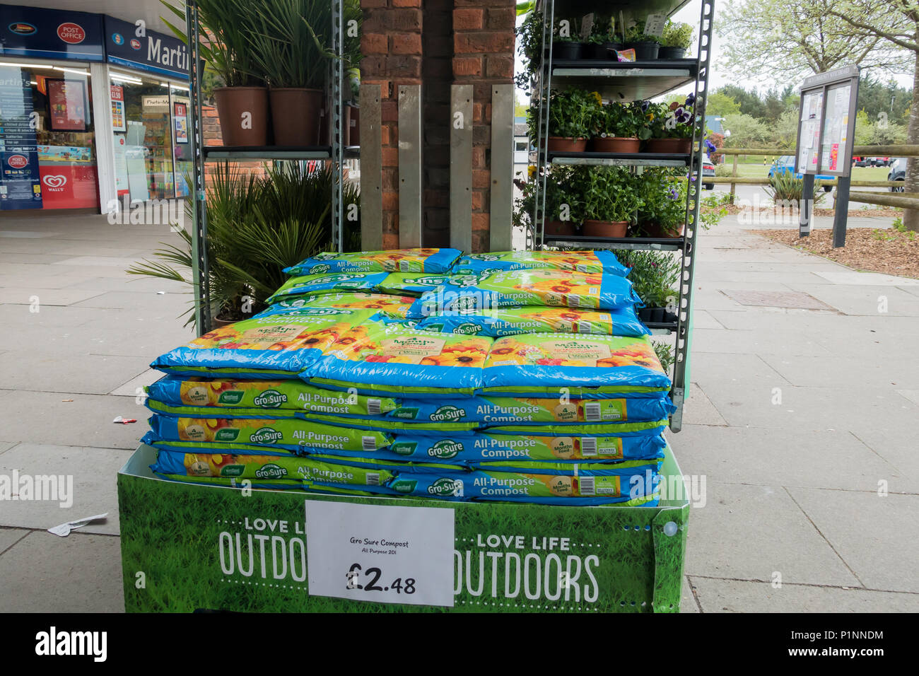 Einige Packungen zu Gro, dass alle Zweck Kompost für den Verkauf vor einige Blumentöpfe außerhalb einer britischen Supermarkt gestapelt Stockfoto