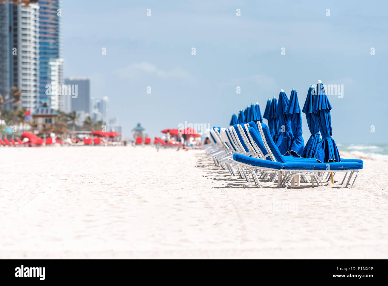 Strand von Sunny Isles während der sonnigen Tag im Norden von Miami, Florida, Blau und Rot liegen, durch Resort, die Küste Wolkenkratzer Bau Stockfoto