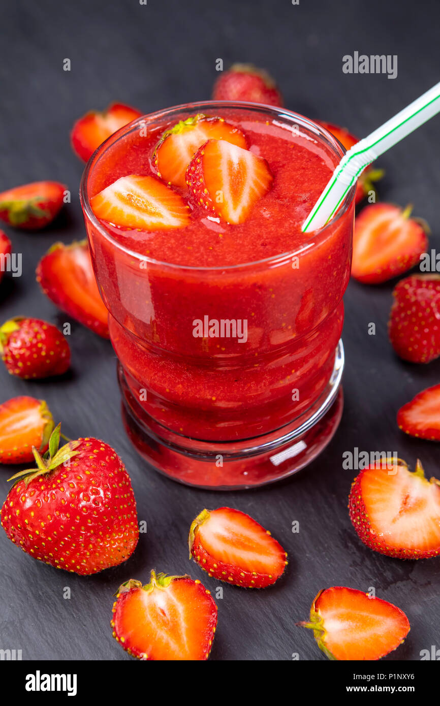 Erdbeere im frischen Smoothie auf Schwarz. Gesund trinken Konzept. Fokus auf Erdbeere im Glas mit Smoothie! Stockfoto