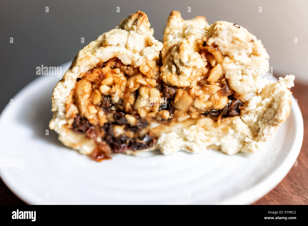 Nahaufnahme der große Scheibe Stück Apfelkuchen Kuchen, Obst und gesunde goldene Kruste mit Zimt auf weiße Platte, Tabelle, Rosinen Stockfoto