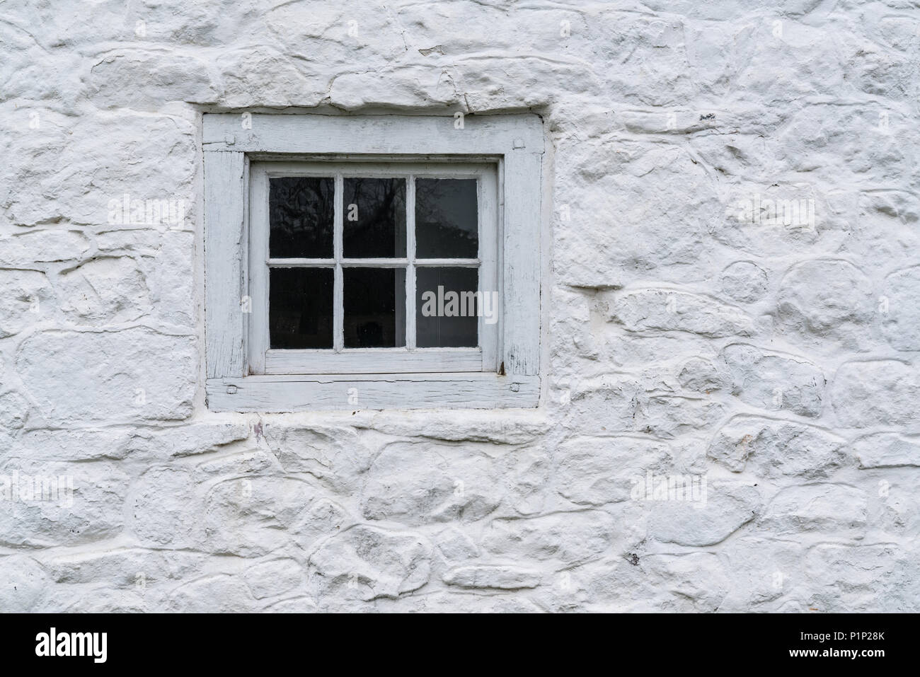 Alte weiße Fenster auf einem Stein weiß getünchten Häuschen Stockfoto