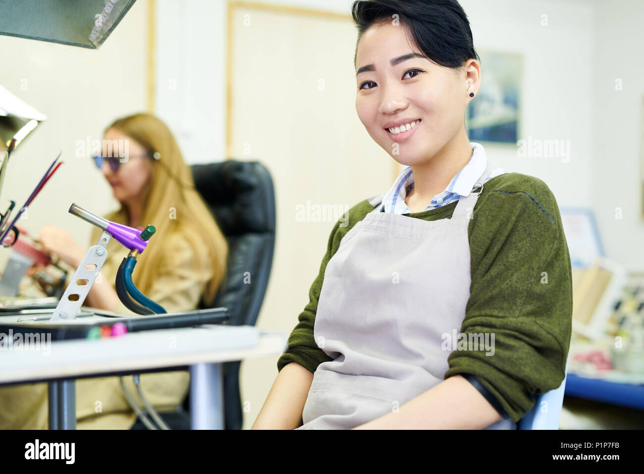 Lächelnd asiatische Künstler in Werkstatt Stockfoto