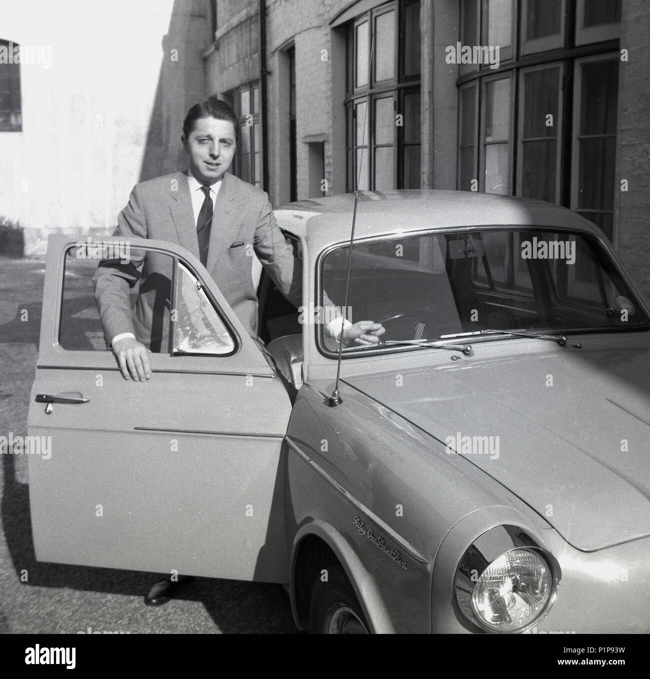 1951, in der Nähe der Richmond Park, außerhalb eines Mews Haus, einem jungen gut-zu-Gentleman ist erhalten in seine Riley "One-point-Fünf 'BMC motorcar, Richmond, Surrey, England, UK. Mit es ist gutes Handling, Compact, Sport - Limousine Styling, der einen Pint - fünf war das perfekte Fahrzeug für die Menschen in der Stadt. Stockfoto