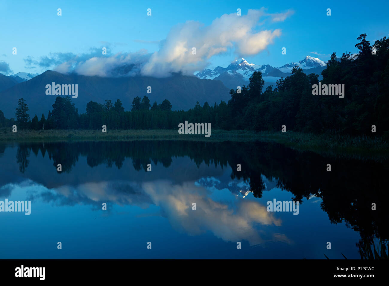 Gipfel des Mt Tasman (rechts) und Aoraki/Mt Cook (ganz rechts) in Lake Matheson, Westland National Park, West Coast, South Island, New Zealan wider Stockfoto