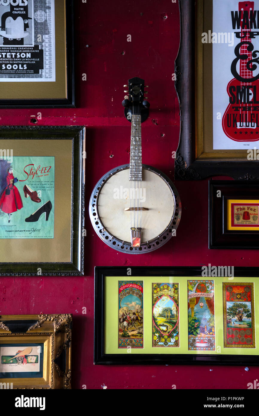 Banjo und Bilderrahmen an der Wand im Inneren der schrulligen Fez Bar in Ramsgate, Kent, Großbritannien hängen Stockfoto