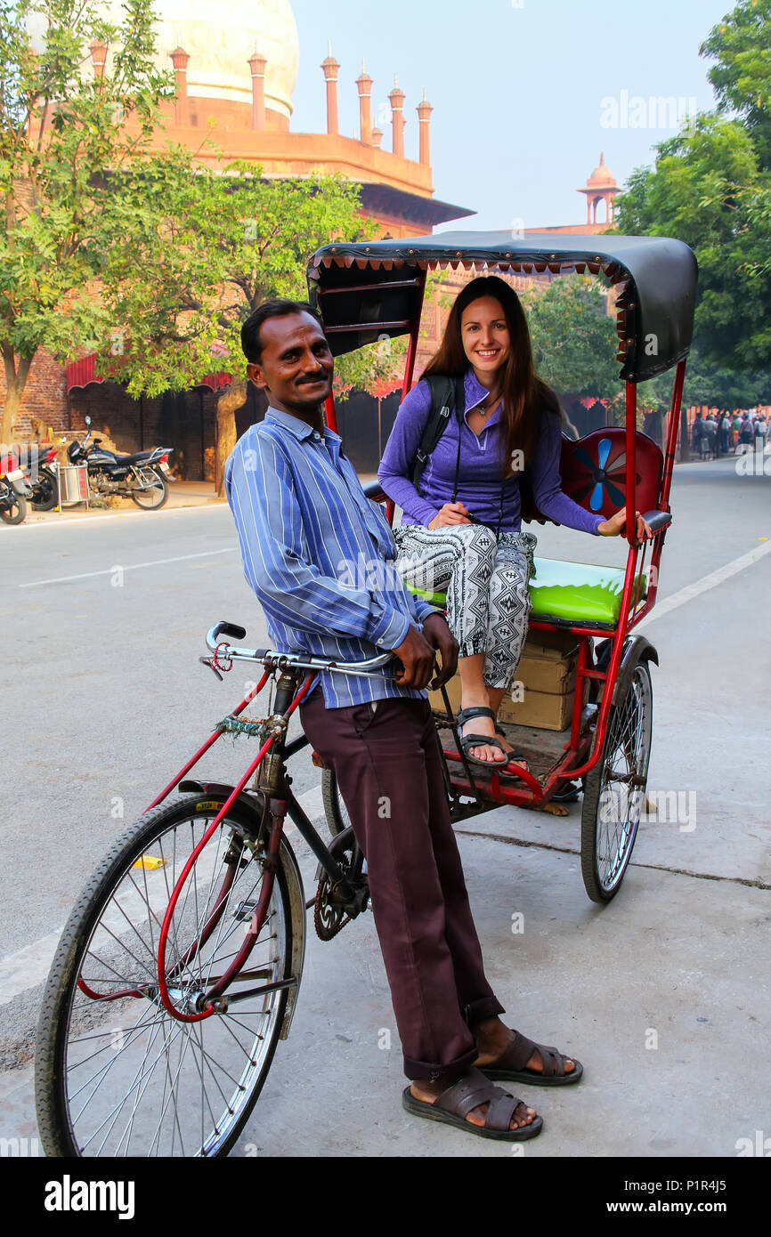 Cycle rickshaw mit einem Touristen auf seinem Pedicab im Taj Ganj Nachbarschaft von Agra, Uttar Pradesh, Indien. Agra ist eines der bevölkerungsreichsten Städte Stockfoto