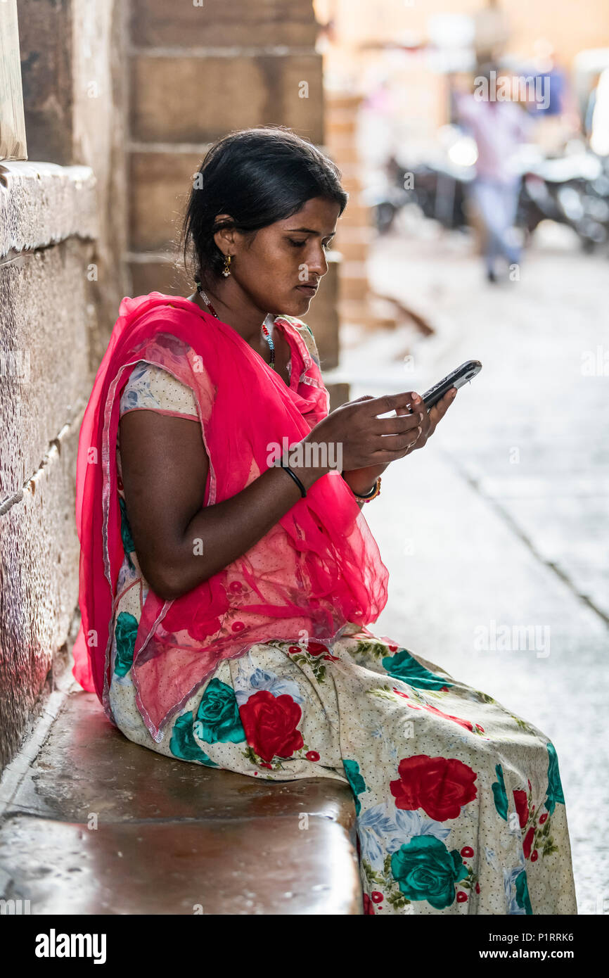 Eine junge indische Frau sitzt mit ihrem Handy, Jaisalmer, Rajasthan, Indien Stockfoto