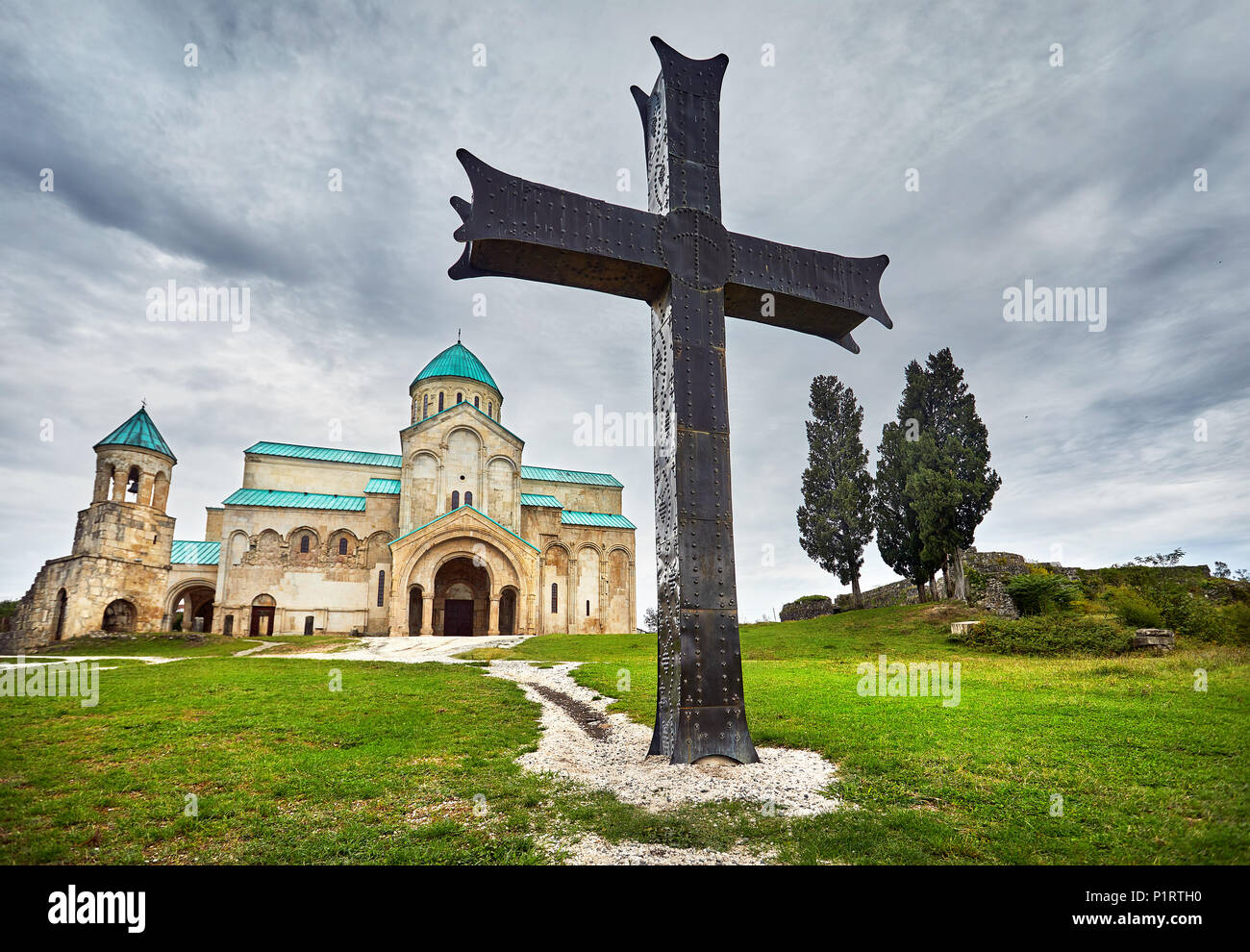 Big Iron Cross vor bagrati Kirche bei bedecktem Himmel in Kutaissi, Georgien Stockfoto