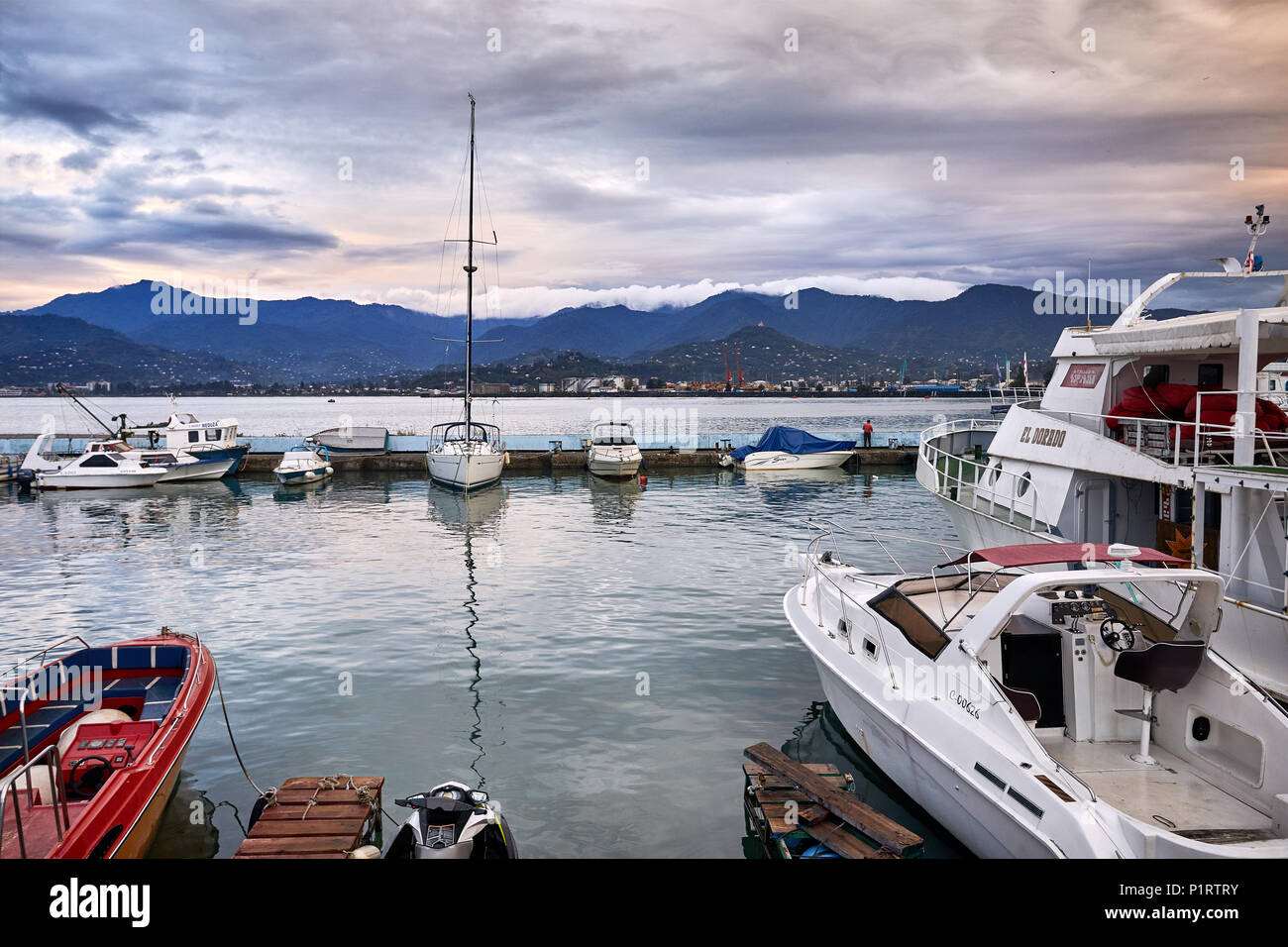 BATUMI, Georgien - OKTOBER 3, 2017: Hafen mit Fischerbooten und Yacht an bedeckt stürmischen Himmel Stockfoto