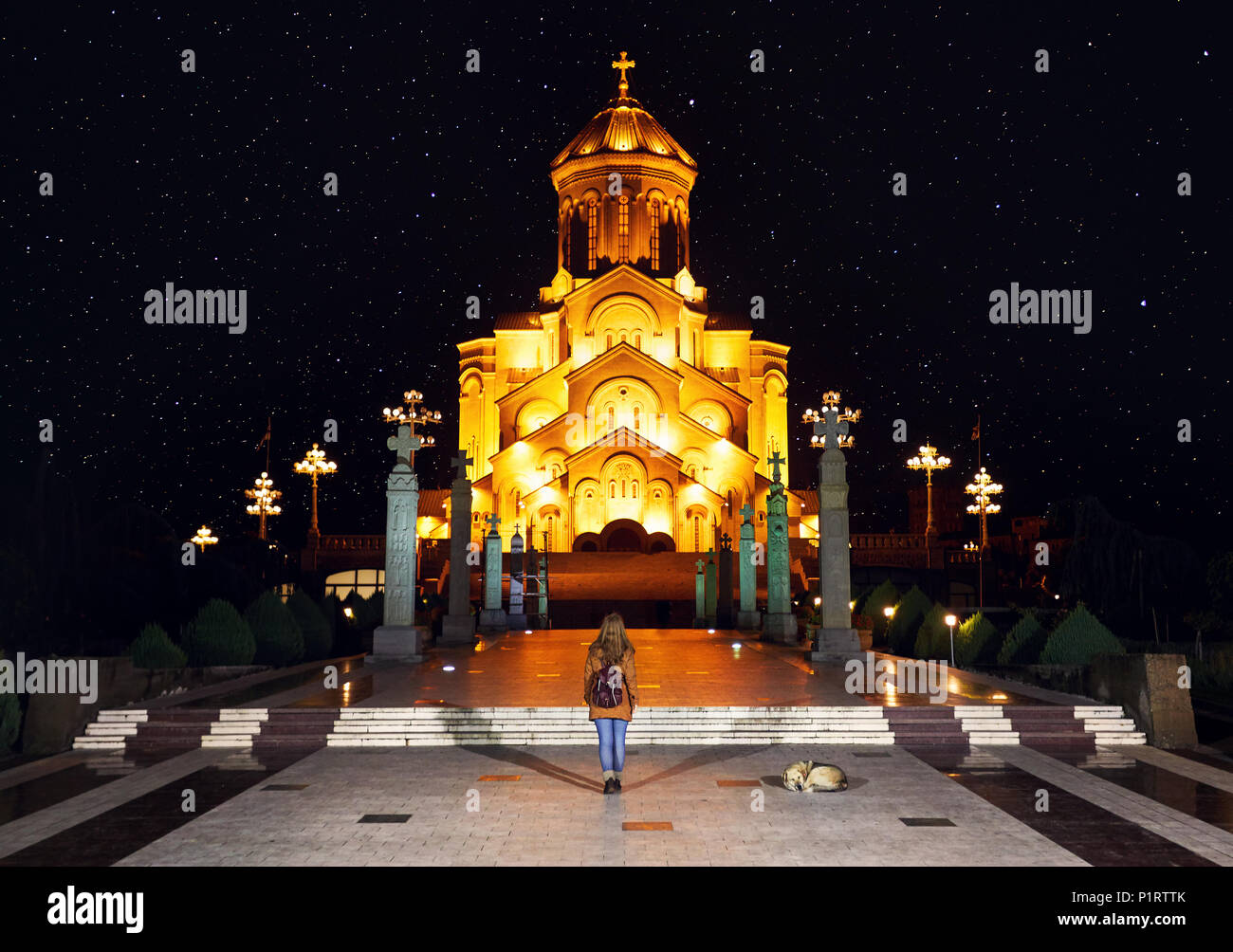 Die Frau in der Nähe der Heiligen Dreifaltigkeit Tsminda Sameba Kathedrale oder Kirche bei Nacht in Tiflis, Georgien Stockfoto