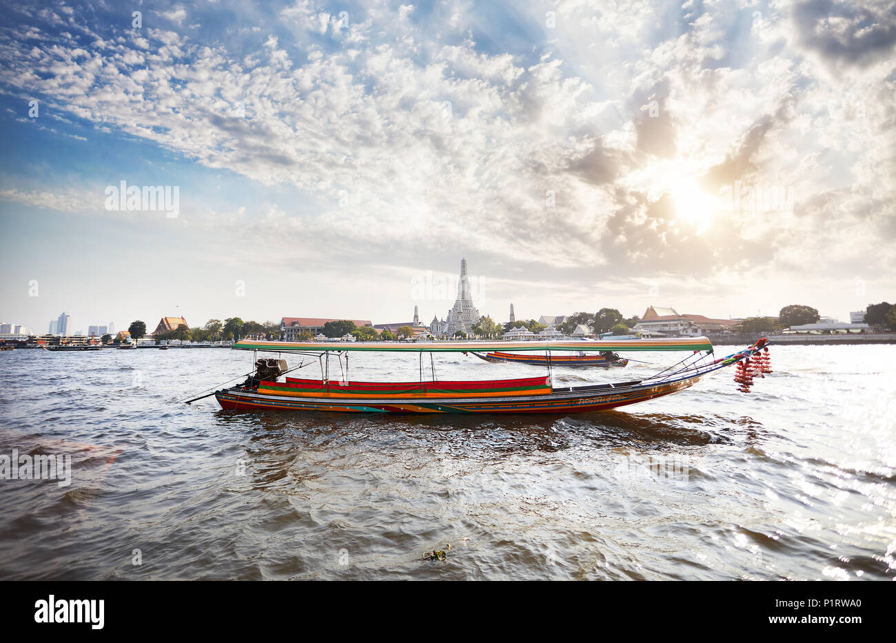 Traditionelle Thai Long tail Boot im Chao Phraya River in der Nähe von Wat Arun bei Sonnenuntergang in Bangkok, Thailand Stockfoto