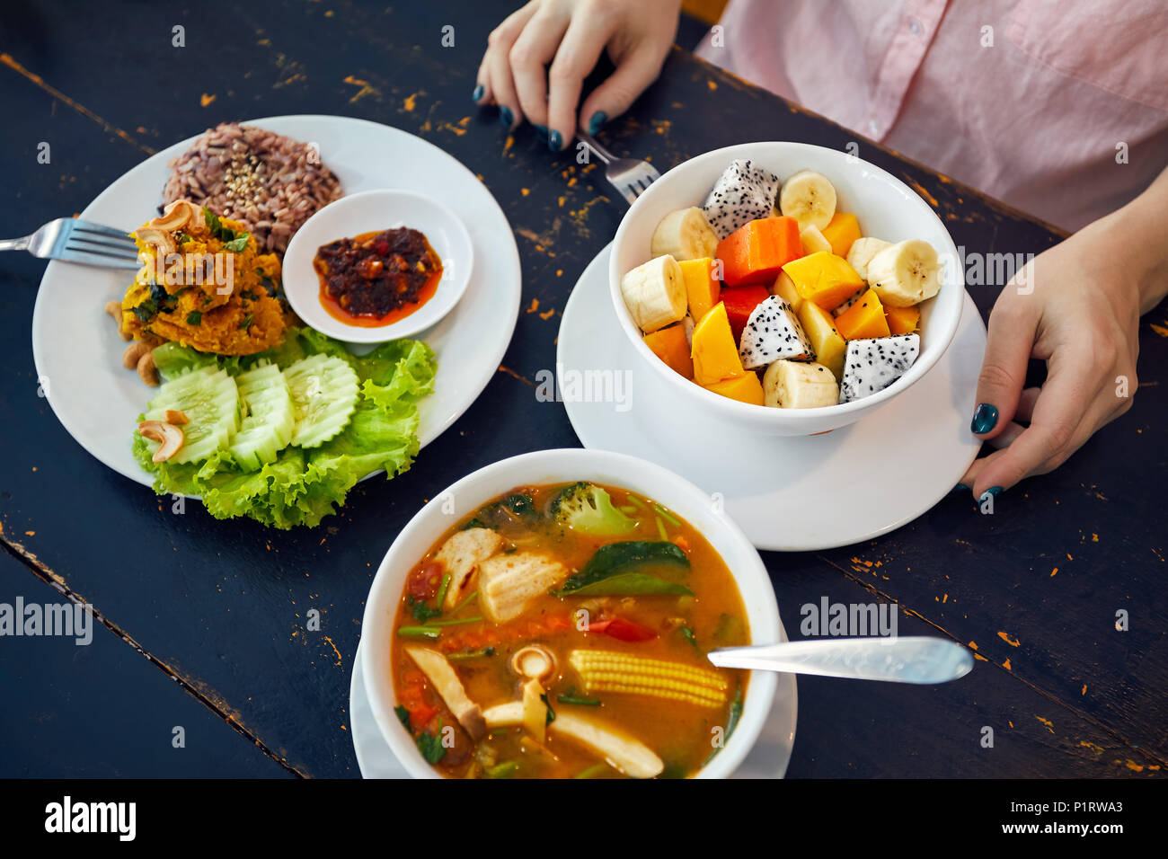 Traditionelle thailändische sauer Suppe Tom Yam in vegetarischen Variation, Curry Reis und Obst Salat in veganes Restaurant in Bangkok. Stockfoto