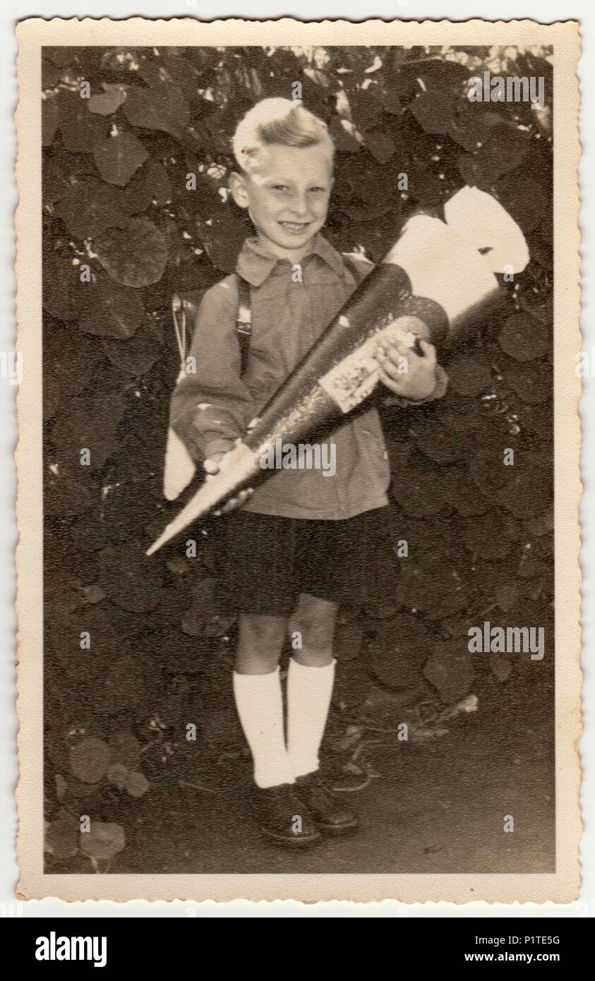 Deutschland - circa 1940s: Vintage Foto zeigt Schüler Junge mit der chultute" oder Schule Kegel, Süßigkeiten für den ersten Tag in der Schule. Studio Foto mit Sepia Tönung. Stockfoto