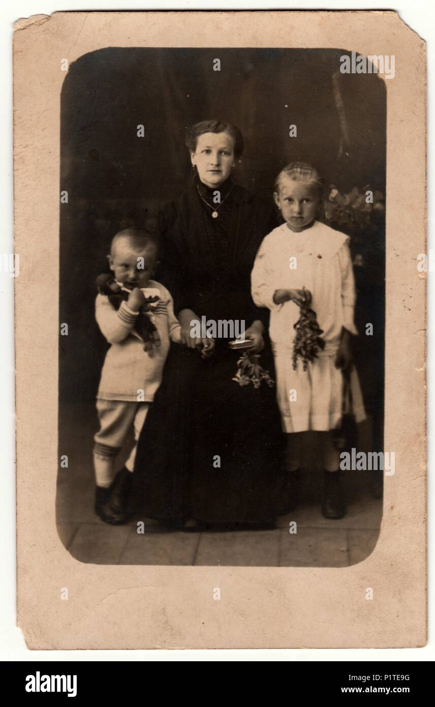 Deutschland - circa 1930s: photo Vintage zeigt die Frau und ihre Kinder in ein Fotostudio. Junge trägt eine Sailor Girl Kostüm und weißes Kleid. Retro black & white Studio Fotografie mit Sepia Effekt. Stockfoto