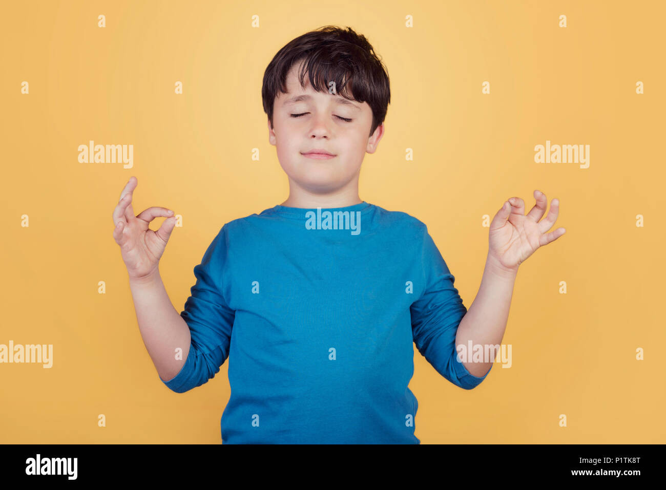 Portrait von Kind auf Yoga Meditation auf gelbem Hintergrund Stockfoto