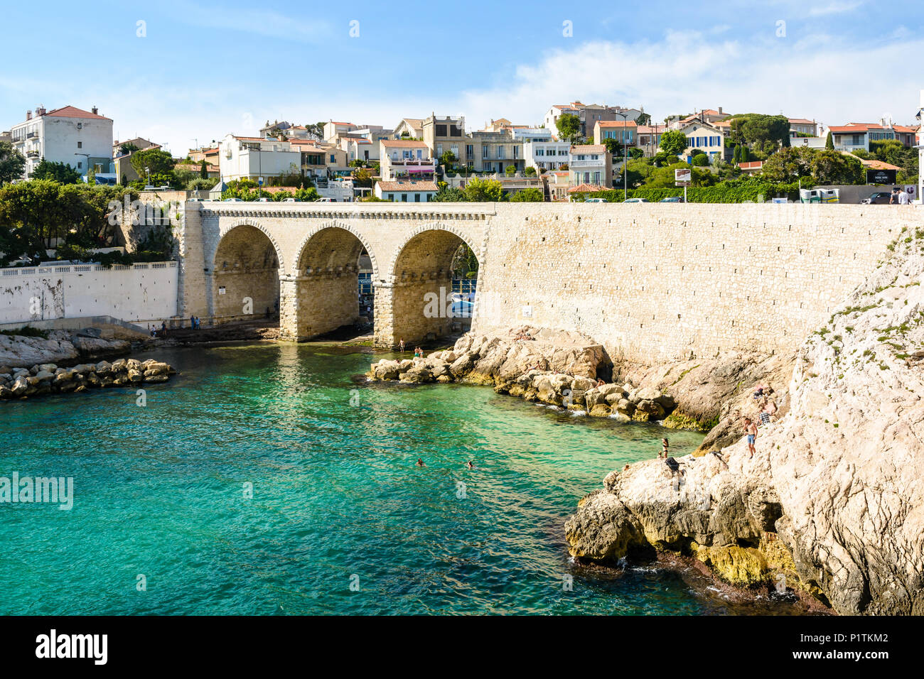 Blick auf die Bucht und die Brücke von fausse Monnaie (wörtlich "Falschgeld") in Endoume Bezirk mit Menschen beim Sonnenbaden auf den Felsen und Schwimmen in t Stockfoto