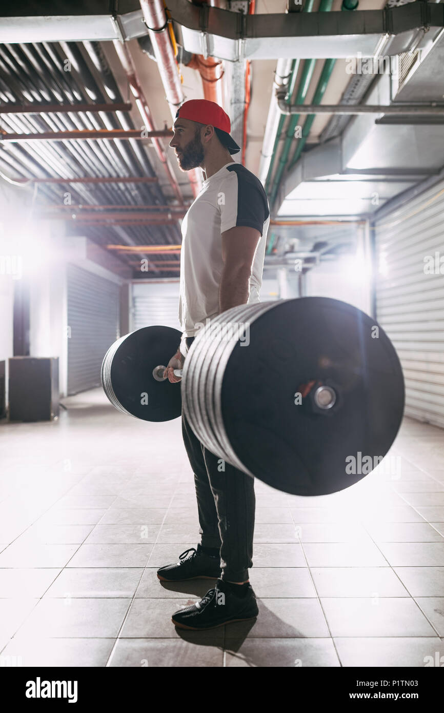 Junge muskulöse Mann bereit, Übung in der garage Gym zu deadlift. Stockfoto